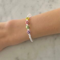 a woman's arm with a bracelet made out of beads and letters on it