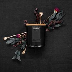 a black candle surrounded by flowers on a black background with the words, love is in the air