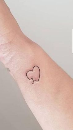 a small heart tattoo on the wrist