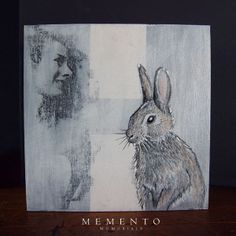 a drawing of a rabbit next to a man's face on a wooden table