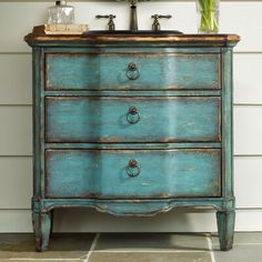 an old blue dresser with flowers on top