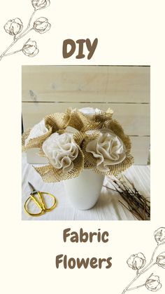 a white vase filled with flowers on top of a table next to scissors and yarn