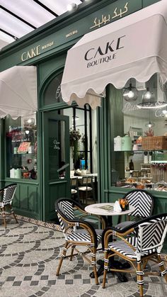 an outdoor cafe with tables, chairs and umbrellas on the sidewalk outside in front of it