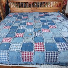 a bed with blue and red checkered bedspread on top of wooden headboard