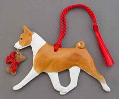 a brown and white dog ornament with a red ribbon around it's neck