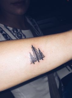 a person with a pine tree tattoo on their arm