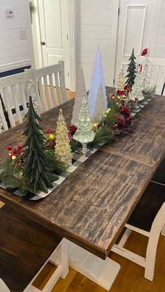 a wooden table topped with christmas trees and candles on top of it's sides