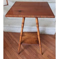 a small wooden table sitting on top of a hard wood floor