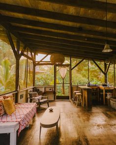 the inside of a house with wood flooring and walls, windows, and furniture