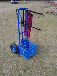 a blue hand truck sitting on top of a grass covered field