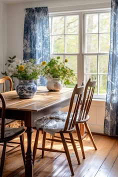 a wooden table sitting in front of a window with blue drapes on the windowsill