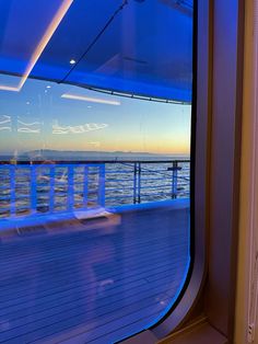 the sun is setting over the ocean as seen through a window on a ferry boat