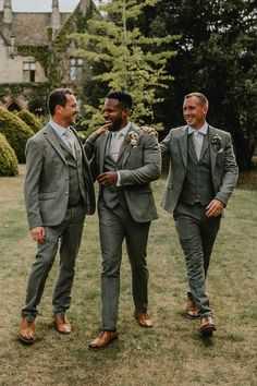 three men in suits standing next to each other