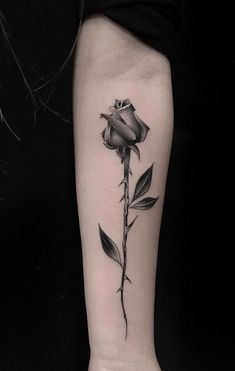 a black and white rose tattoo on the arm