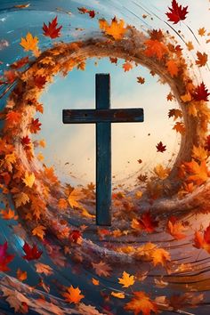 a cross surrounded by autumn leaves in the sky