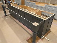 an unfinished kitchen island in the middle of a room with cabinets and drawers on it