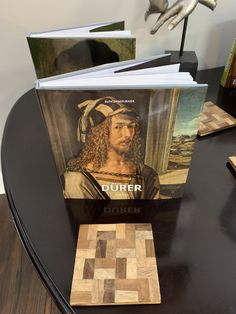 there is a book on top of a table with books in front of it and an image of a man