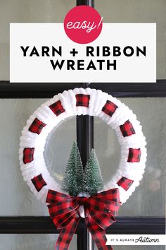 yarn and ribbon wreath hanging on the front door with christmas tree decoration in red and white