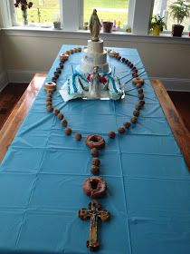 a blue table with a cake on it and beads in the shape of a cross