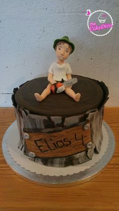 a cake with a boy sitting on top of it