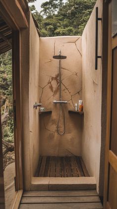 an outdoor shower with wooden flooring and walls