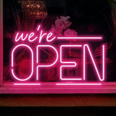 we're open neon sign displayed in window