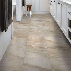 a kitchen with white cabinets and gray flooring