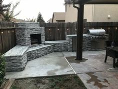 an outdoor grill and seating area in a backyard