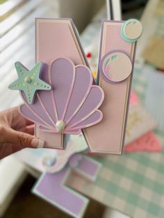 a person holding up a card with an image of a shell and starfish on it