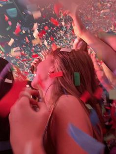 a group of people at a party with confetti and streamers