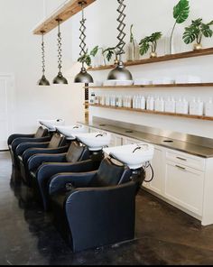 a row of chairs sitting next to each other in front of a counter with lots of bottles on it