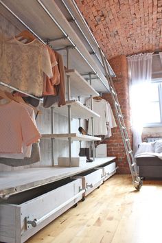 a room that has some clothes on shelves