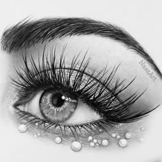 an eye with long lashes and pearls on it