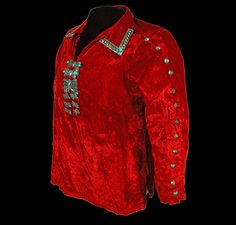 a red jacket with silver sequins on the chest and collar, in front of a black background