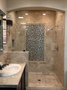 a bathroom with a walk in shower next to a sink