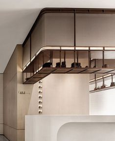 a kitchen with white counter tops and wooden shelves on the wall, along with hanging utensils