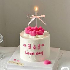 a white cake with pink hearts on it and a candle in the middle that says 365 love day