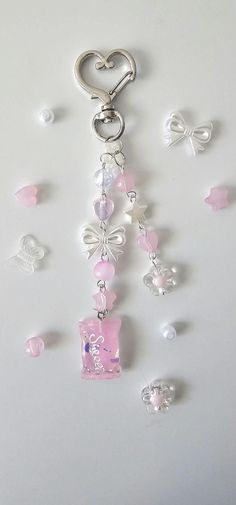 a keychain with pink and white beads hanging from it's side on a table