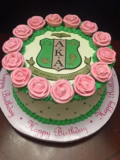 a birthday cake decorated with pink roses on a table