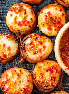 baked potatoes with red sauce in a wooden bowl on a blue table cloth next to a spoon