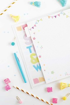 a notepad with tassels on it next to a pen and some candy