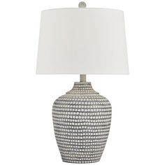 a blue and white table lamp with a white shade on the top, sitting against a white background