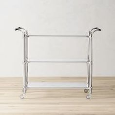 a metal rack with three wheels on top of a wooden floor