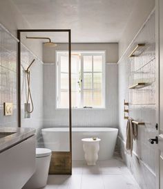 a white bathroom with a tub, toilet and sink next to a large open window