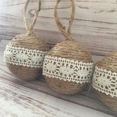 three twine balls with lace on them are sitting on a wooden surface, ready to be used as decorations