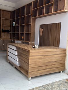 an empty kitchen with wooden cabinets and white tile flooring on the side walk way