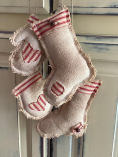 two burlocks hanging from a door with red and white striped socks on them