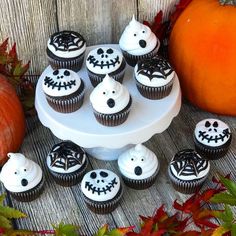 cupcakes decorated with white frosting and black decorations