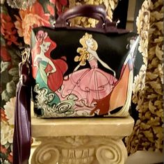 A Disney Parks Exclusive Purse Featuring Ariel, Aurora, And Snow White. It Has Handles And An Adjustable Detachable Shoulder Strap. A Zippered Compartment Inside Never Used. Man Made Material 9”H D 4” D X 8” W Disney Themed Multicolor Bags For Fan Events, Themed Multicolor Bags For Disney Fan Events, Cute Multicolor Bags For Disney Trips, Disney Style Crossbody Bag For Daily Use, Themed Multicolor Rectangular Bag, Disney Satchel Bag For Everyday Use, Disney Style Shoulder Bag With Removable Pouch, Disney Bags For Daily Use, Disney Red Rectangular Bag