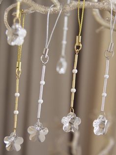 four different necklaces hanging from a tree branch